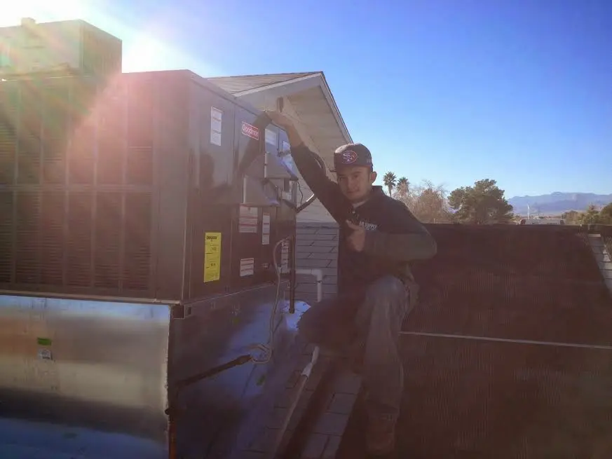 HVAC technician performing Boiler Repair on a rooftop unit in Sunset Hills
